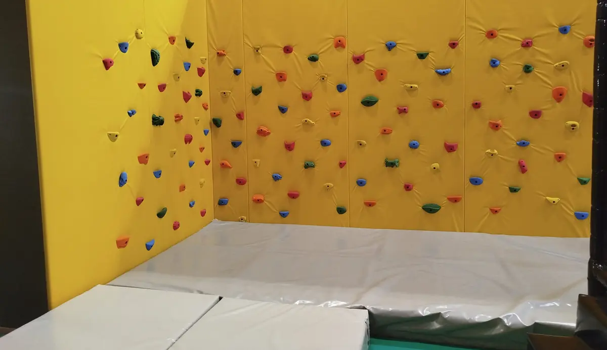 Le mur d’escalade jaune et ses prises colorées