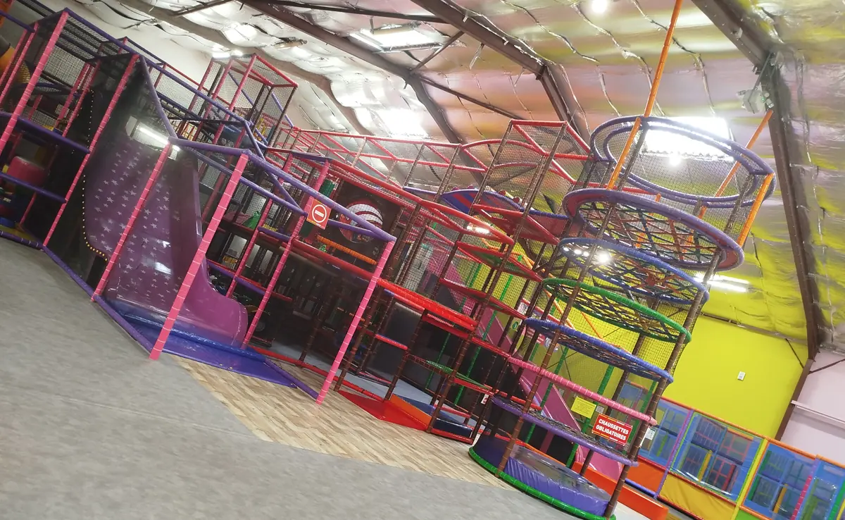 Vue d’ensemble du parc : la grande structure, les trampolines et la tour de jeux